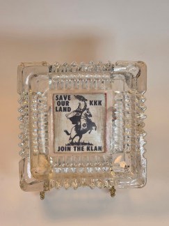 Main Image: A top-down view of a vintage square glass ashtray with a central image of a Klansman on horseback and the text "SAVE OUR LAND KKK JOIN THE KLAN."