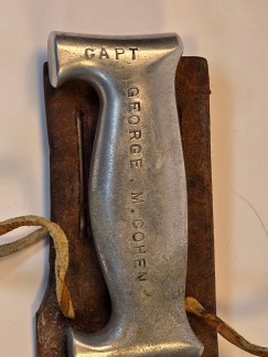 A WWII trench art knife with a metal handle engraved with "CAPT GEORGE M. COHEN" and a custom-made, 1945-dated leather sheath.
