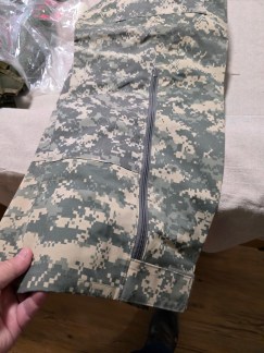 Pair of US Army ECWCS Level VI rain trousers in UCP digital camo, new with tags, showing the full side zippers.