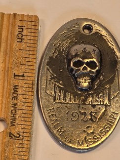 Based on its appearance, text, and function, I would call the object a: Ku Klux Klan (KKK) 1928 Realm of Mississippi Identity Tag (or Membership Token).