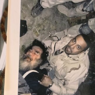 Original color photograph of a disheveled Saddam Hussein during his capture by US forces in Iraq