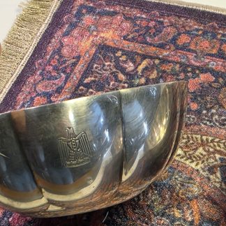 Eagle Detail Close up of engraved Iraqi Eagle of Saladin on silver bowl Detailed view of the pre-1991 Iraqi National Crest. Christofle Mark Christofle France hallmarks stamped on bottom of silver bowl Authentic Christofle France manufacturer stamps and hallmarks. Overhead View Two scalloped edge silver bowls on a miniature rug A pair of 5-inch diameter Iraqi State Silver bowls. Condition View Side profile of silver bowl showing small dents and wear Visible character marks and dents on the silver-plated exterior.