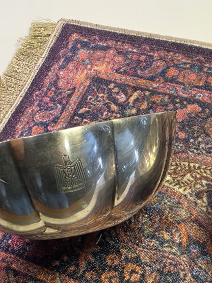 Eagle Detail Close up of engraved Iraqi Eagle of Saladin on silver bowl Detailed view of the pre-1991 Iraqi National Crest. Christofle Mark Christofle France hallmarks stamped on bottom of silver bowl Authentic Christofle France manufacturer stamps and hallmarks. Overhead View Two scalloped edge silver bowls on a miniature rug A pair of 5-inch diameter Iraqi State Silver bowls. Condition View Side profile of silver bowl showing small dents and wear Visible character marks and dents on the silver-plated exterior.