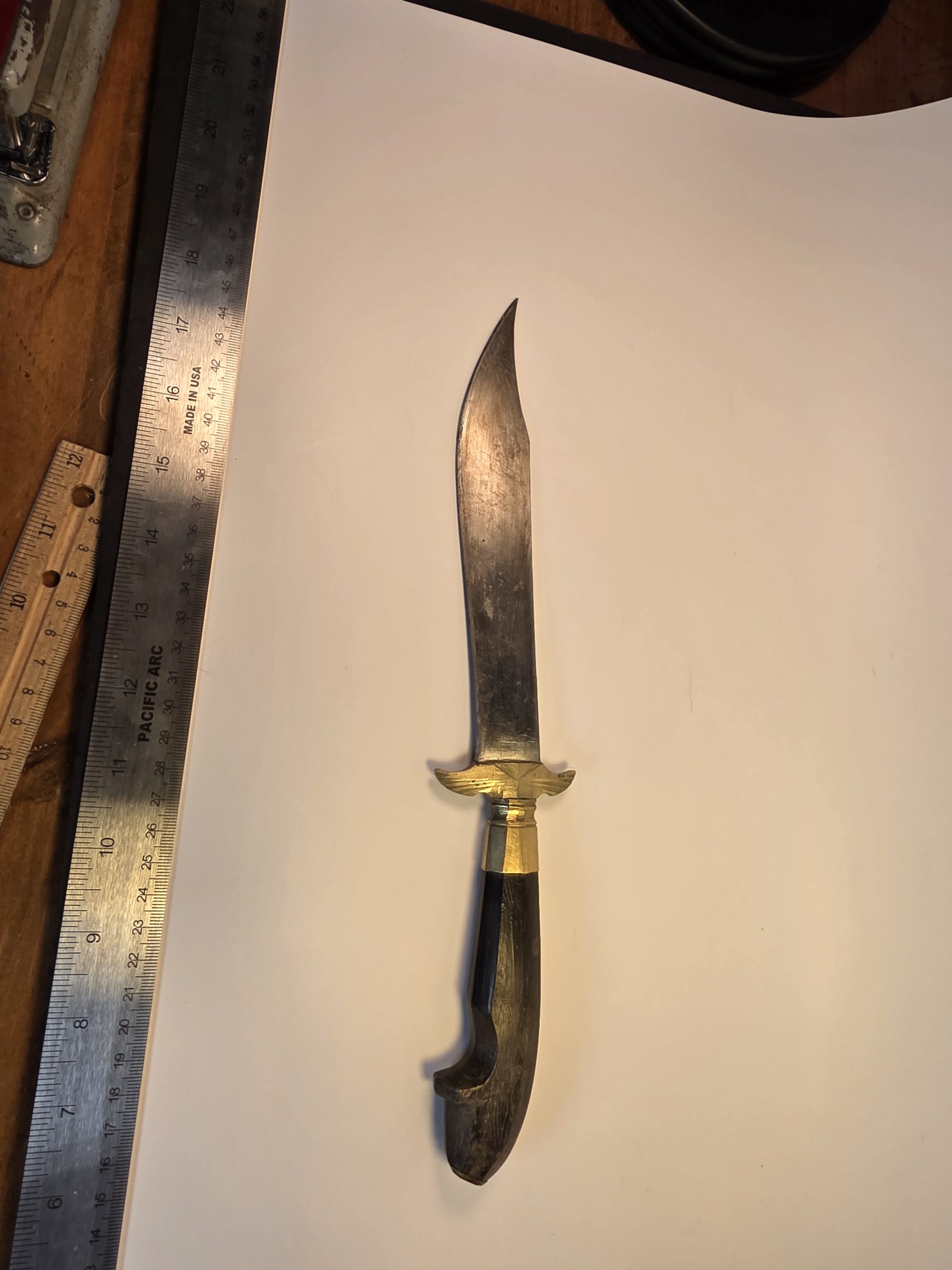 Close-up of a vintage WWII theater knife blade engraved with 'Philippines 1945' and a palm tree illustration.