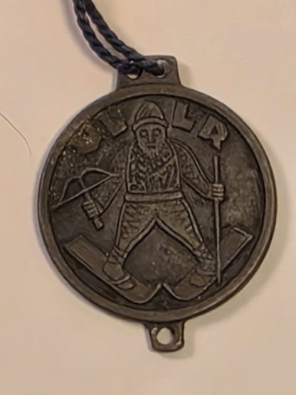 Front view of a German WWII era Ullr medallion depicting the Norse god of skiing with a crossbow.