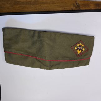 Exterior view of a vintage Boy Scouts of America garrison cap with red piping and a fleur-de-lis patch.